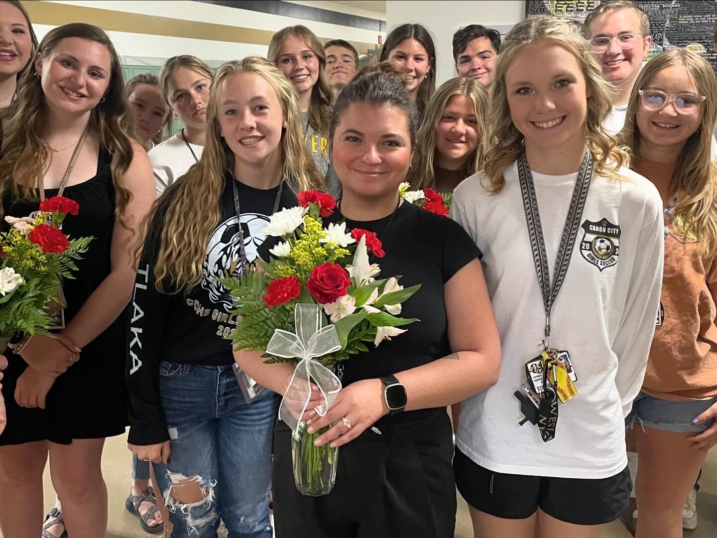 Mrs. Roberts holding flowers with Student Council Members