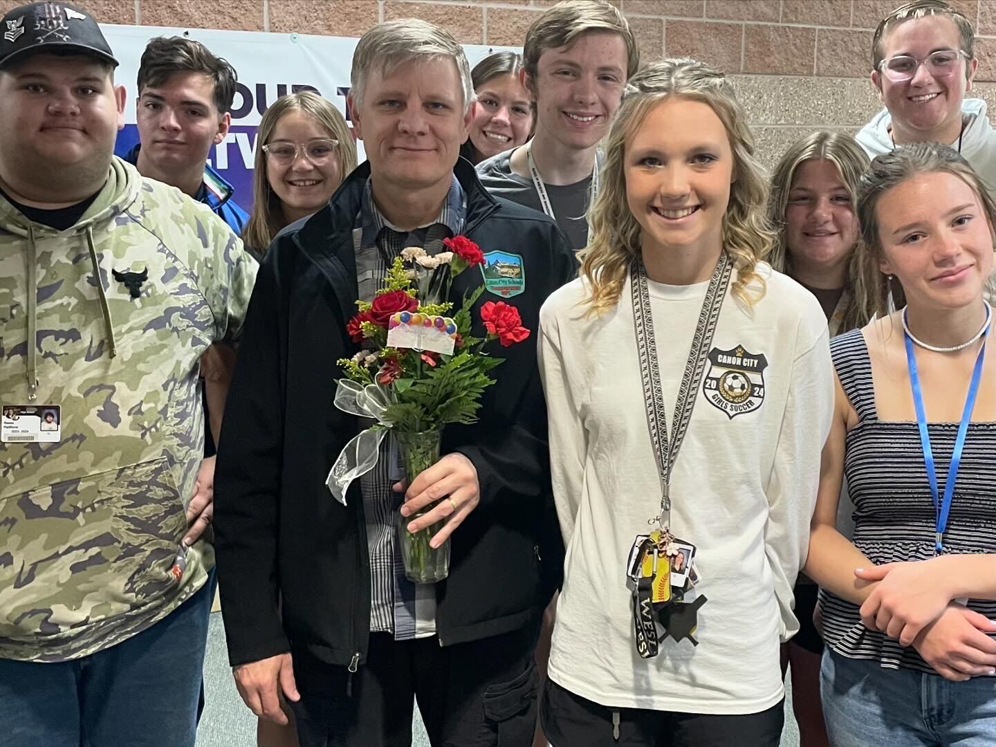 Mr. Fisher holding flowers with Student Council Members