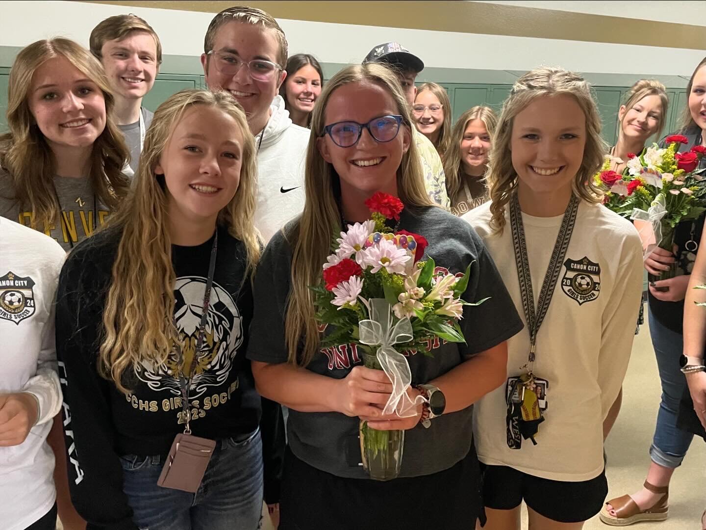 Ms. Lambrecht holding flowers with Student Council Members