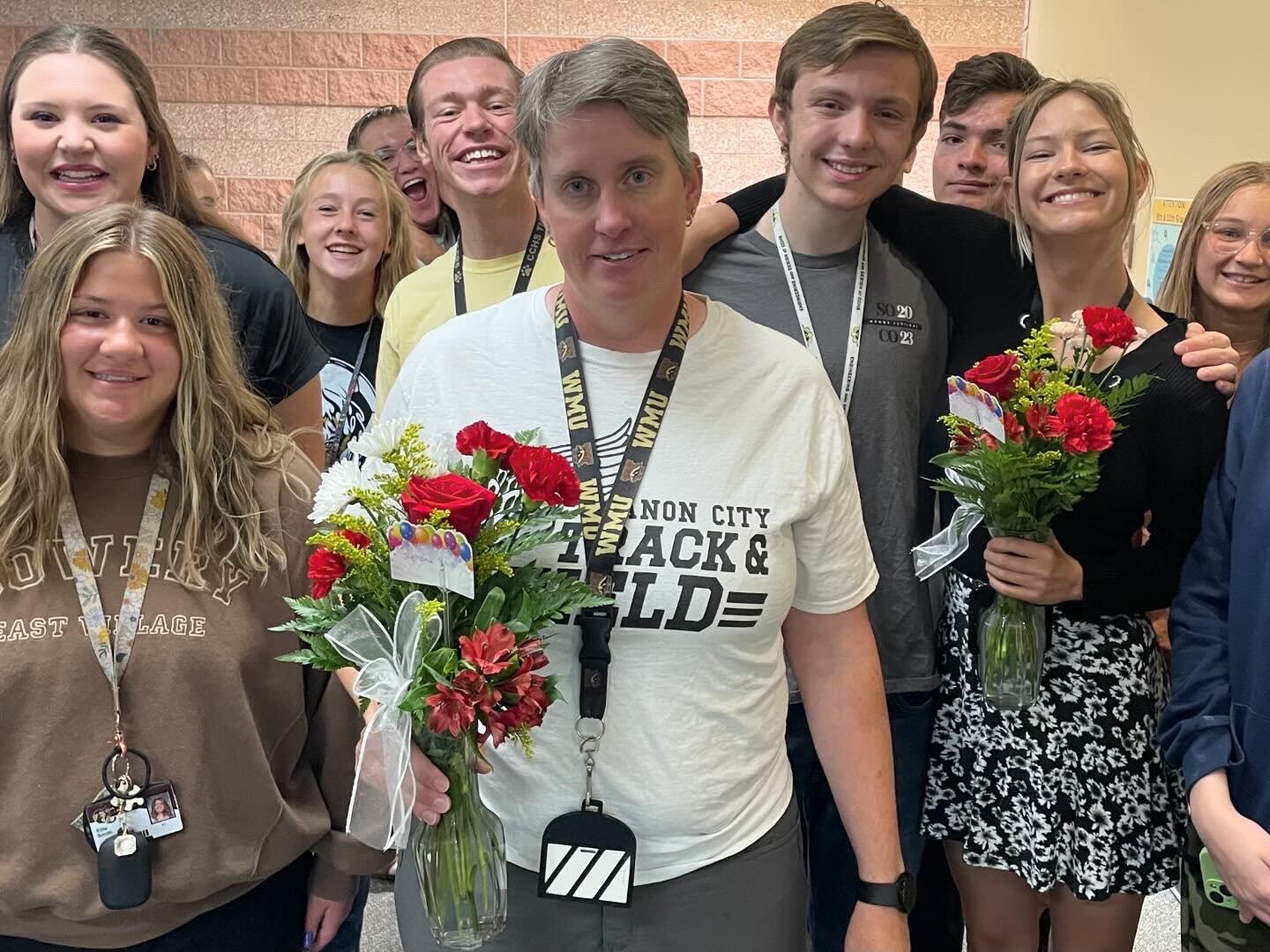 Mrs. Krafft holding flowers with Student Council Members