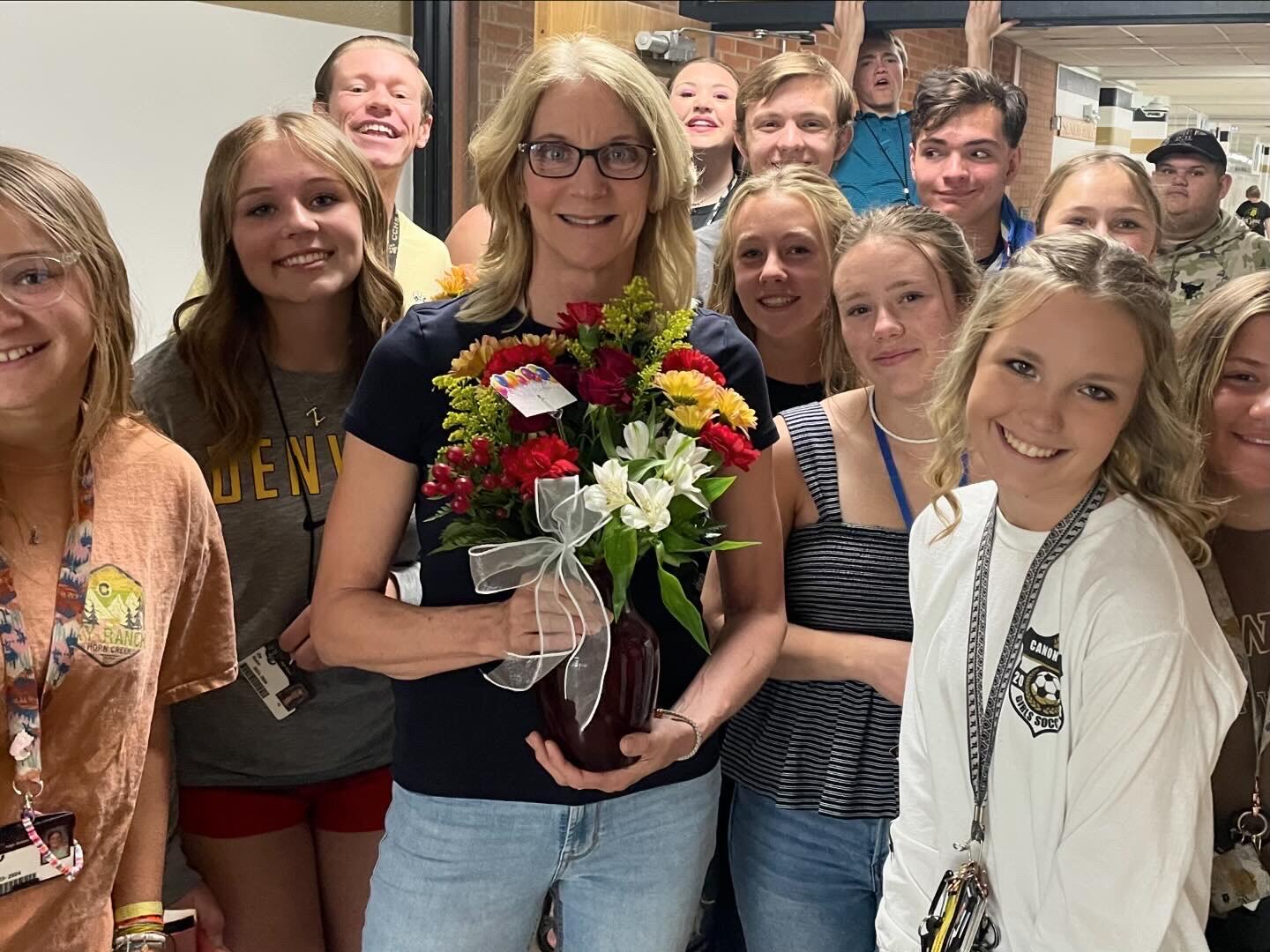 Mrs. Berger holding flowers with Student Council Members